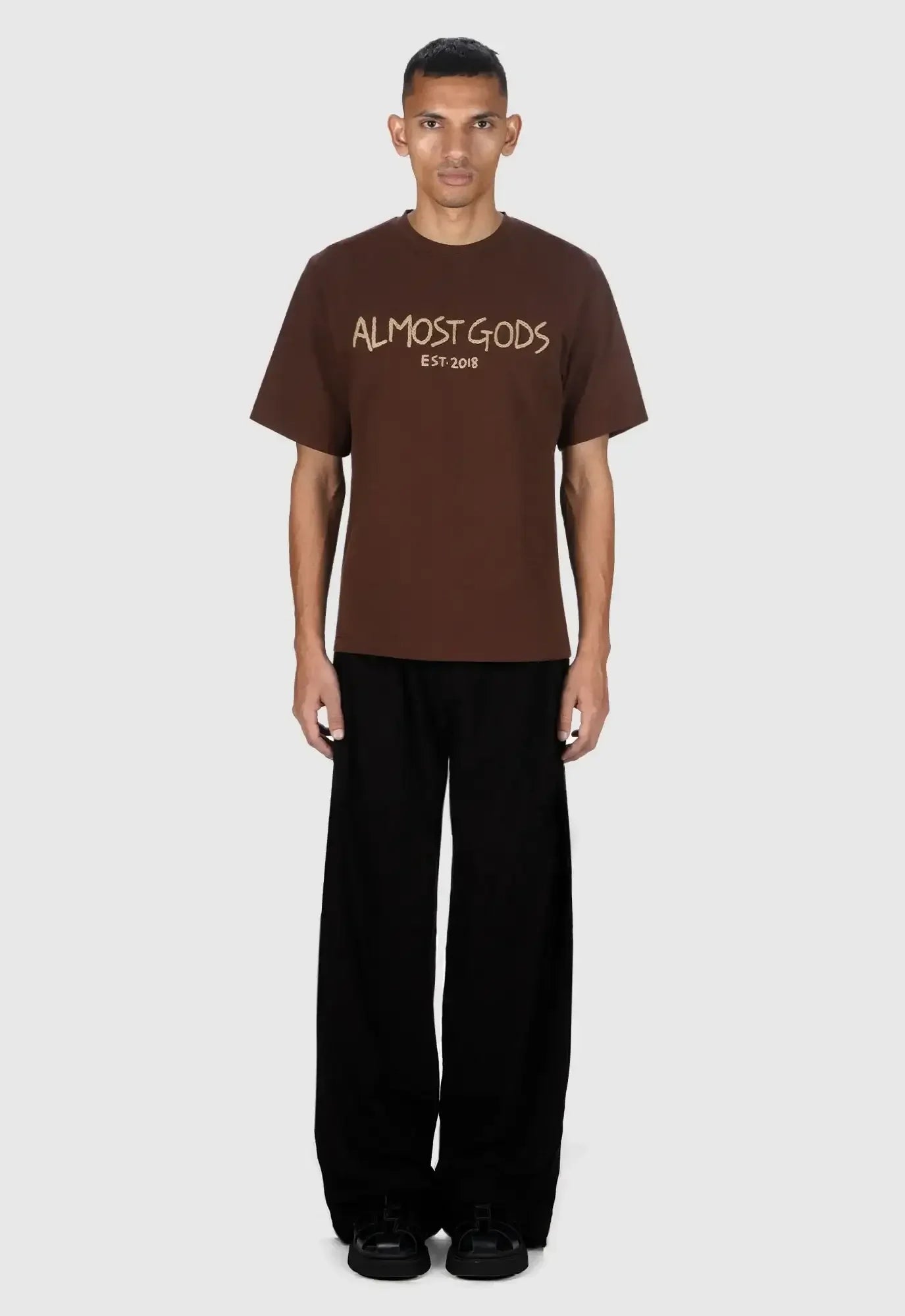Person wearing a brown t-shirt with text on a white background